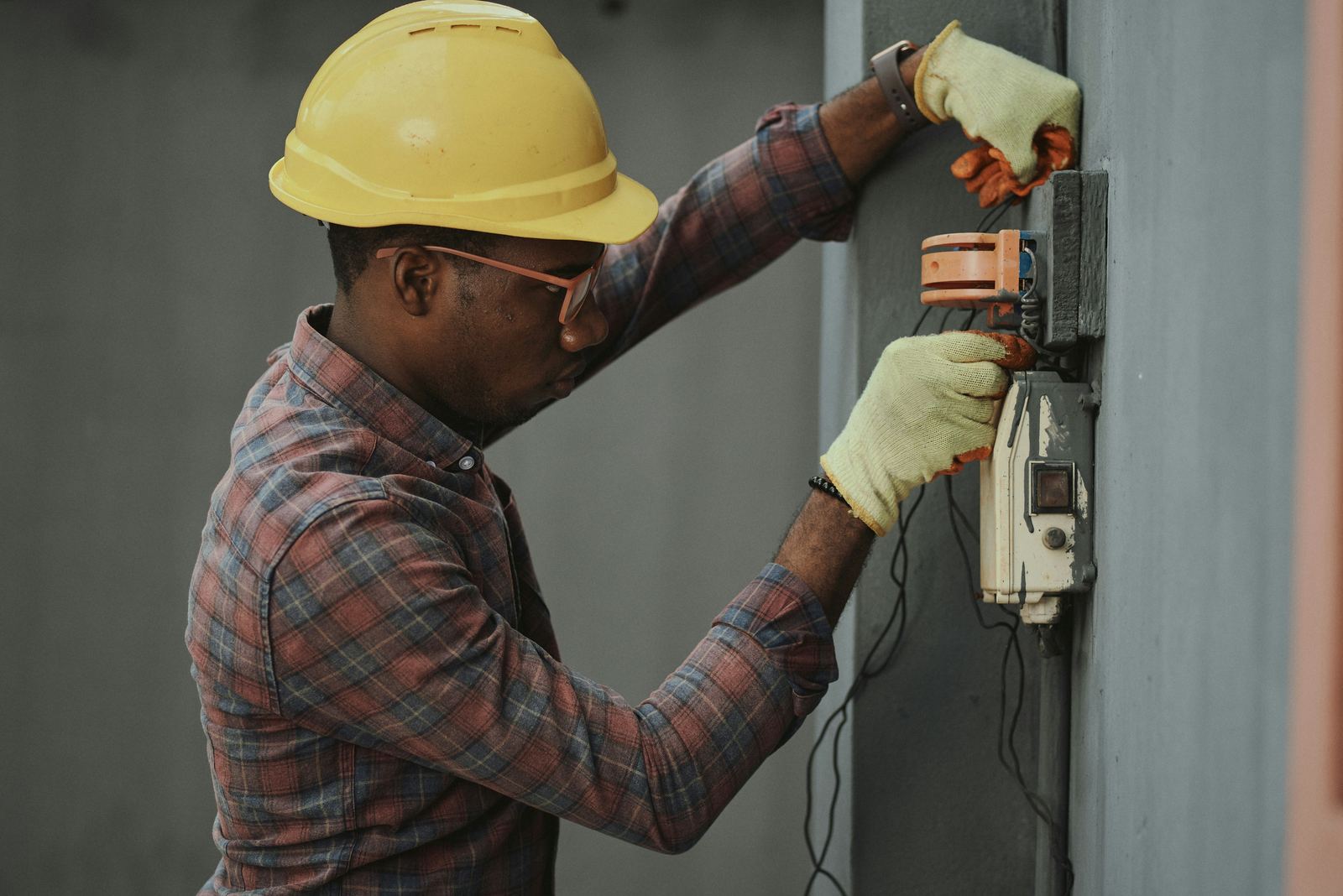 Contractor inspecting field equipment while wearing protective gear