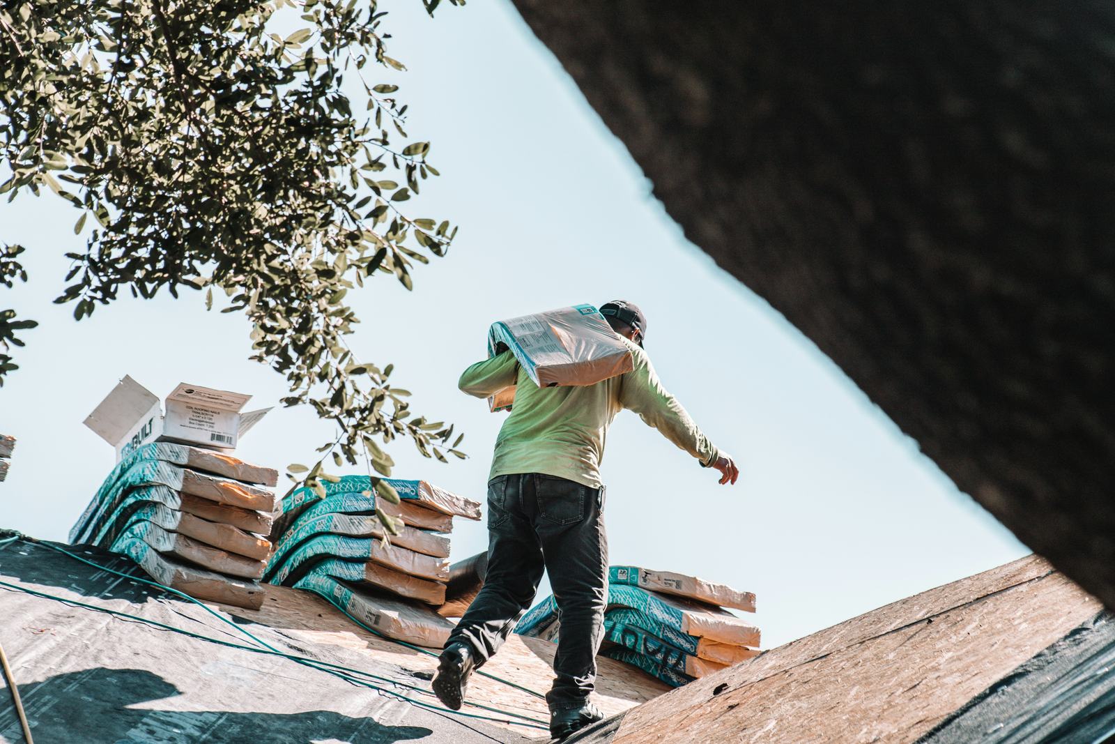 Roofing professional carrying materials